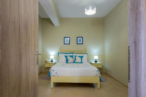 a bedroom with a bed with blue pillows at Nikos & Vassilis apartments Kefalonia in Vlachata