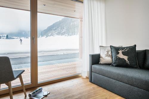 a living room with a couch and a large window at Gabriela Apartments in Mellau