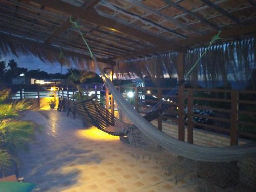 a hammock hanging from a pavilion on a beach at Pousada Mar e Sol in Pipa