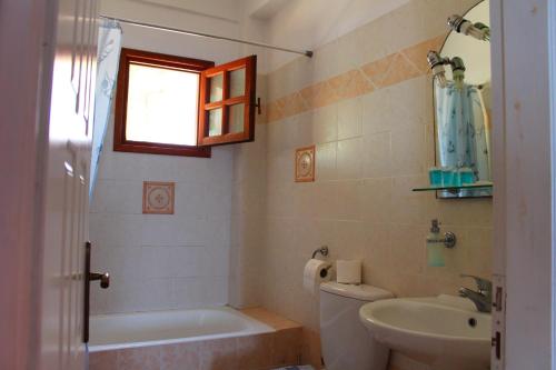 un bagno con vasca, lavandino e WC di Ikaria Utopia - Cusco Studios a Evdilos
