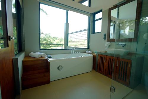 a bathroom with a tub and a sink and a window at Sakuna Arana Resort in Kosgoda