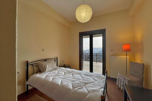 a bedroom with a bed and a window and a lamp at Koukouvistahouse in Kaloskopí
