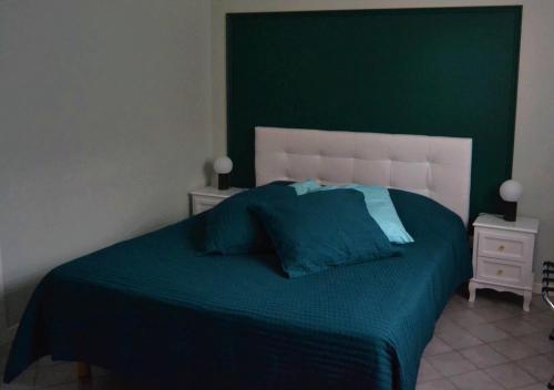 Schlafzimmer mit einem Bett mit einem grünen Kopfteil in der Unterkunft Le Domaine des Gemmes 