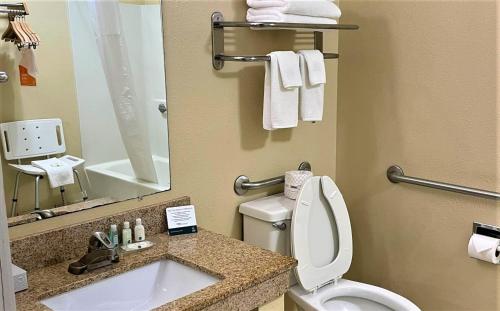 a bathroom with a sink and a toilet and a mirror at Baymont by Wyndham Greenfield in Greenfield