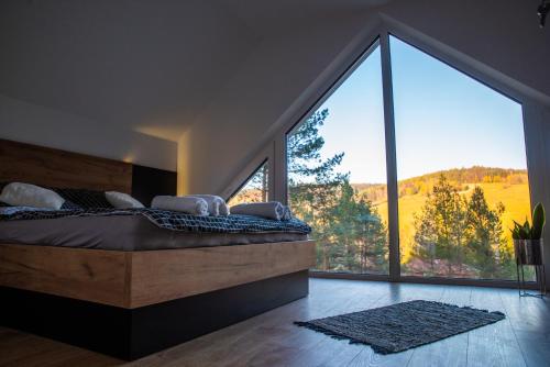 a bedroom with a bed and a large window at Źródło Energii in Małastów