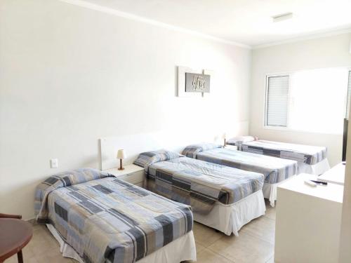 three beds in a room with white walls at Habitat Prime Hotel in Leme