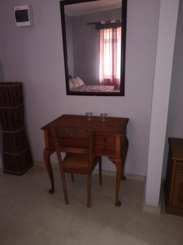 a wooden desk in a room with a mirror at The Tree Of Idleness Guesthouse in Trafalgar