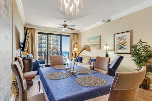 a dining room and living room with a table and chairs at Emerald Grande 922 in Destin