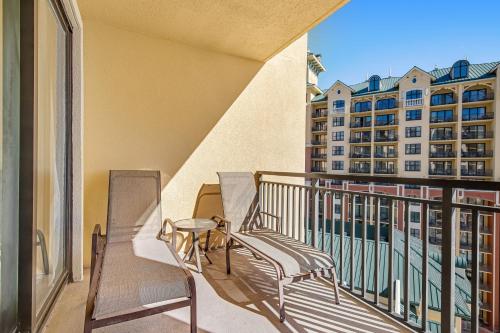 a balcony with two chairs and a view of a building at Emerald Grande 922 in Destin