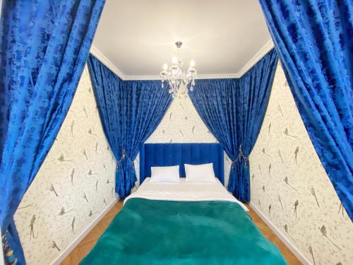 um quarto azul com uma cama com cortinas azuis em Kikasso Art Apart Odessa em Fontanka