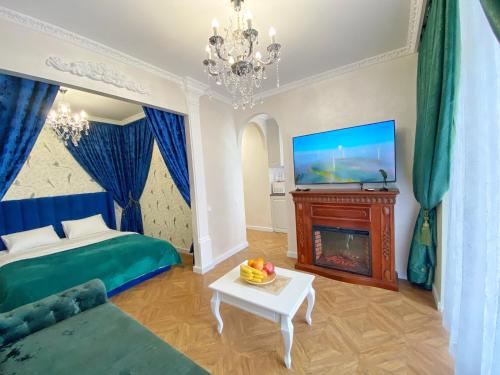 a bedroom with a bed and a fireplace and a tv at Kikasso Art Apart Odessa in Fontanka