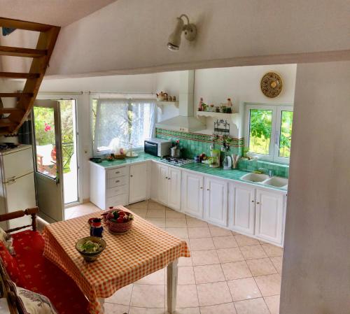 una cocina con armarios blancos y encimeras verdes en Villa Myrto - Beautiful see-view villa, en Stafylos