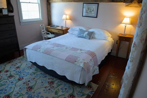 a bedroom with a bed and a desk with two lamps at Shoreham Inn Bed & Breakfast in Shoreham