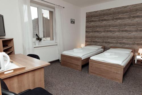 a small room with two beds and a window at PENZION VERMON in Svitavy