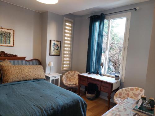 a bedroom with a bed and a desk and a window at Villa Mia in Vence