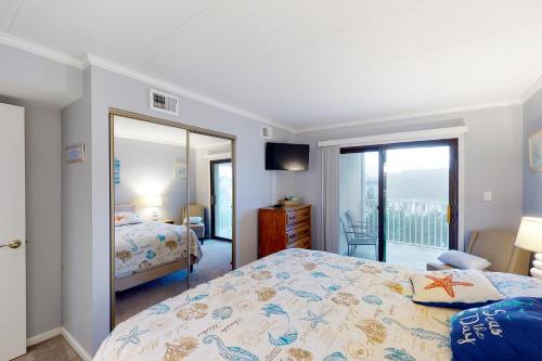 a bedroom with a bed and a sliding glass door at Crystal Sands 403 in Ocean City