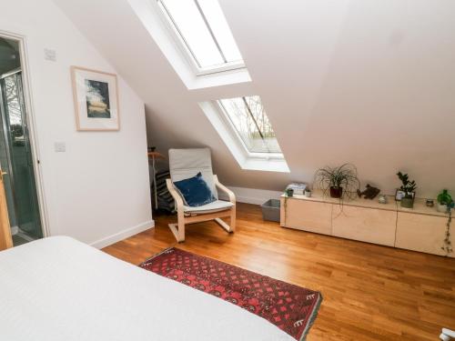 a bedroom with a bed and a chair and a window at The Studio Loft in Tavistock