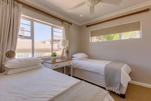 2 camas en un dormitorio con ventana en Jakkalsbessie Breeze - full inverter, en Wilderness