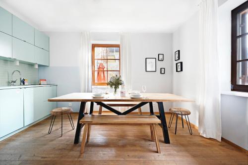 una cucina con tavolo e sedie in legno in una stanza di numa I Flute Apartments a Salisburgo