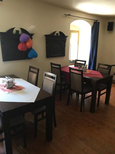 a dining room with tables and chairs and a painting on the wall at Penzión Príjemný Oddych in Banská Štiavnica
