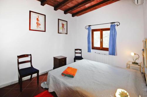 a bedroom with a bed and two chairs and a window at Holiday home, Monteggiori in Santa Lucia