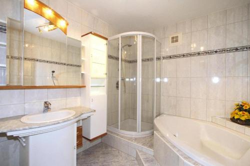 a bathroom with a tub and a sink and a shower at Apartment Rössl Itter - OTR07519-RYA in Itter