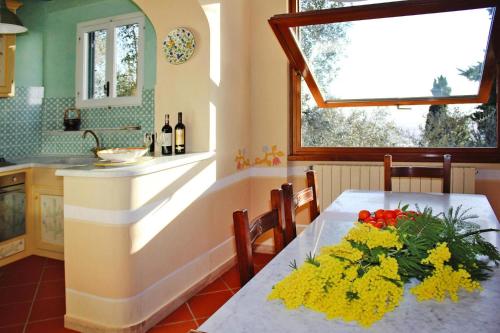 a kitchen with a table with flowers on it at Holiday home, Monteggiori in Santa Lucia