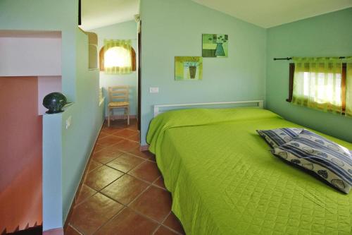 a bedroom with a green bed and a chair at Holiday home, Monteggiori in Santa Lucia