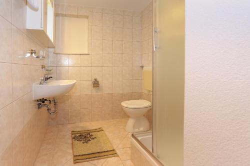 a bathroom with a toilet and a sink at Apartment 5, first floor in Rogoznica
