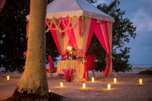 - une tente sur la plage avec une table et des bougies dans l'établissement Coral Reef Resort & Spa, Havelock, à Havelock Island