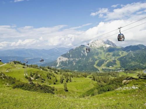 a group of gondolas flying over a green mountain at Hotel Nassfeld in Sonnenalpe Nassfeld