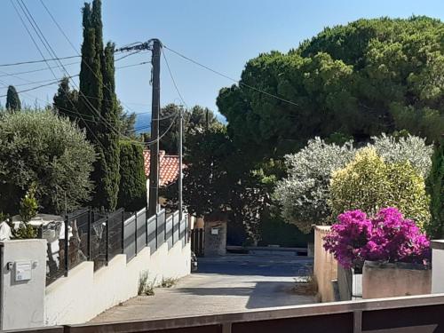 uma rua com uma cerca e flores no passeio em Chez Pierrot 2 em Bandol