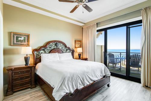 a bedroom with a bed and a balcony with the ocean at Emerald Grande III in Destin
