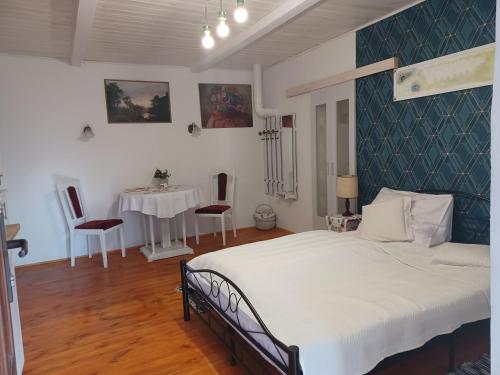 a bedroom with a bed and a table and chairs at Magdolna Vendégház Magánszálláshely in Écs