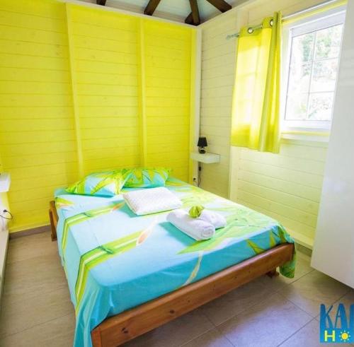 een gele kamer met een bed met handdoeken erop bij Gite Maya in Émilien