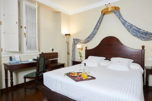 a bedroom with a bed with a tray of food on it at Las Casas de El Arenal in Seville