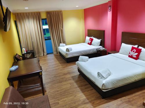 a hotel room with two beds and a desk at Hotel Sunjoy9 Bandar Sunway in Petaling Jaya