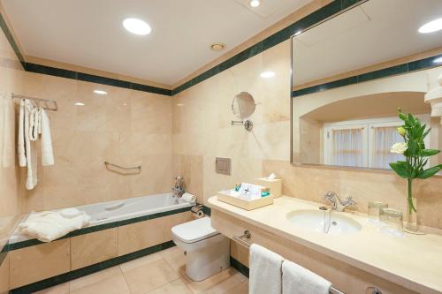 a bathroom with a tub and a toilet and a sink at Las Casas de El Arenal in Seville