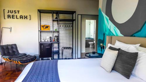 a bedroom with a large bed and a chair at LOTE20 Hotel Boutique in Bento Gonçalves