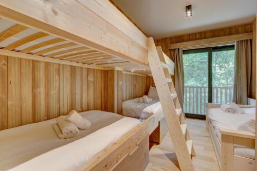 deux lits superposés dans une chambre en bois avec balcon dans l'établissement Chalet La Mésange Boréale, à Morzine