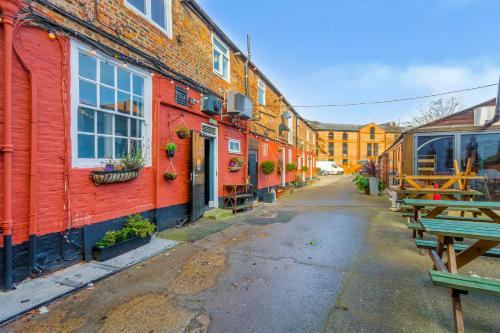 uma rua vazia com edifícios vermelhos e mesas de piquenique em The Watergate Inn em York