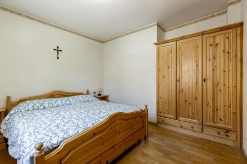 a bedroom with a wooden bed and a cross on the wall at Solaia in Mazzin