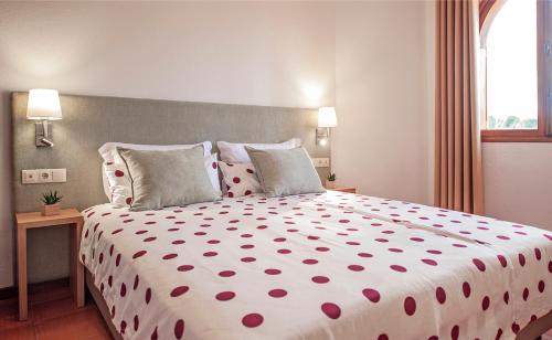 1 dormitorio con 1 cama grande con lunares rojos en Theresia's en Porto Santo