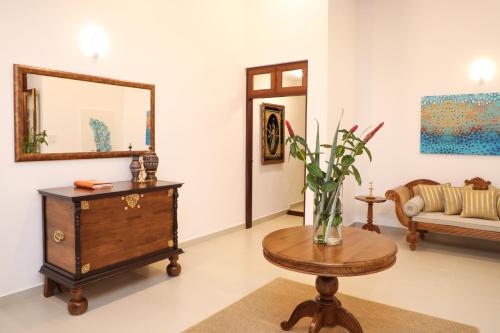 a living room with a table and a mirror at Anodawa Boutique Villa in Tangalle