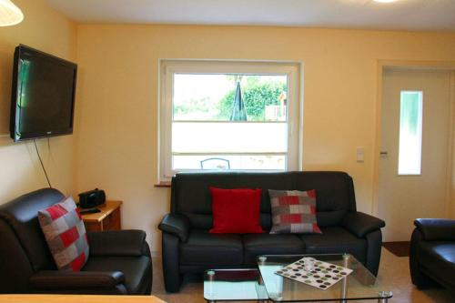 a living room with a couch and a window at Ferienhäuser Mittelhof in Bad Berleburg