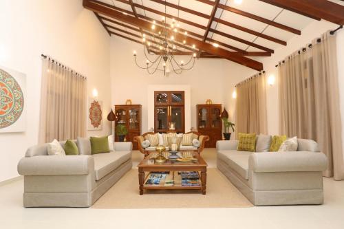a living room with two couches and a coffee table at Anodawa Boutique Villa in Tangalle