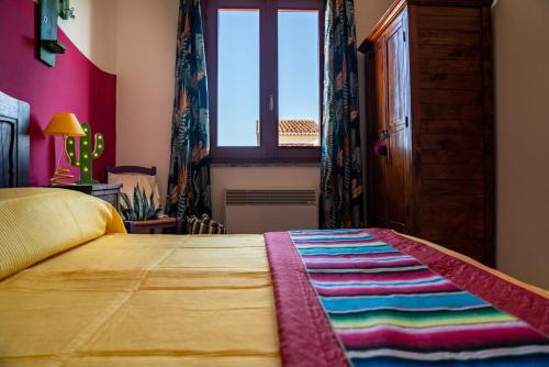 a bedroom with a bed with a colorful blanket on it at Nora Guesthouse Rooms and Villas in Pula