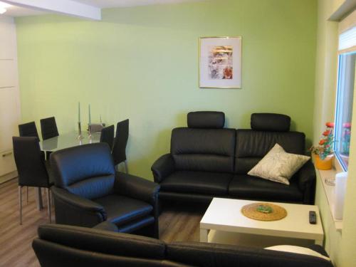 a living room with a couch and chairs and a table at Ferienhäuser Mittelhof in Bad Berleburg