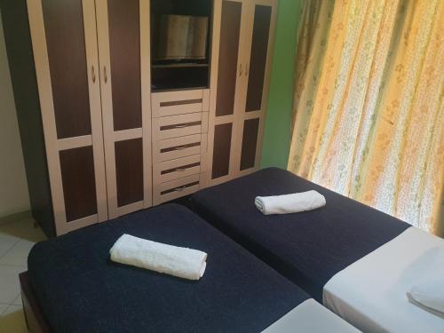two towels are sitting on two beds in a bedroom at Apartment Rina in Sarandë
