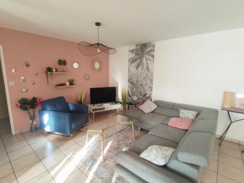 a living room with a couch and a tv at TERLA Bel Appartement 3 Pieces Clim & Parking in Saint-Pierre